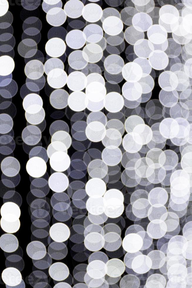 Abstract bokeh of white city lights on black background. defocused and blurred many round light photo