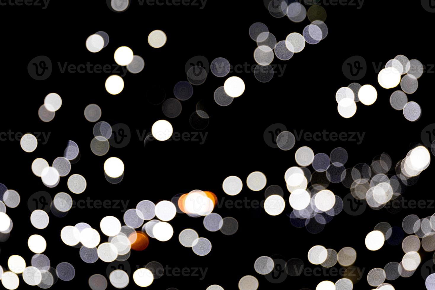 Abstract light bokeh as background defocused and blurred many round light on black background photo