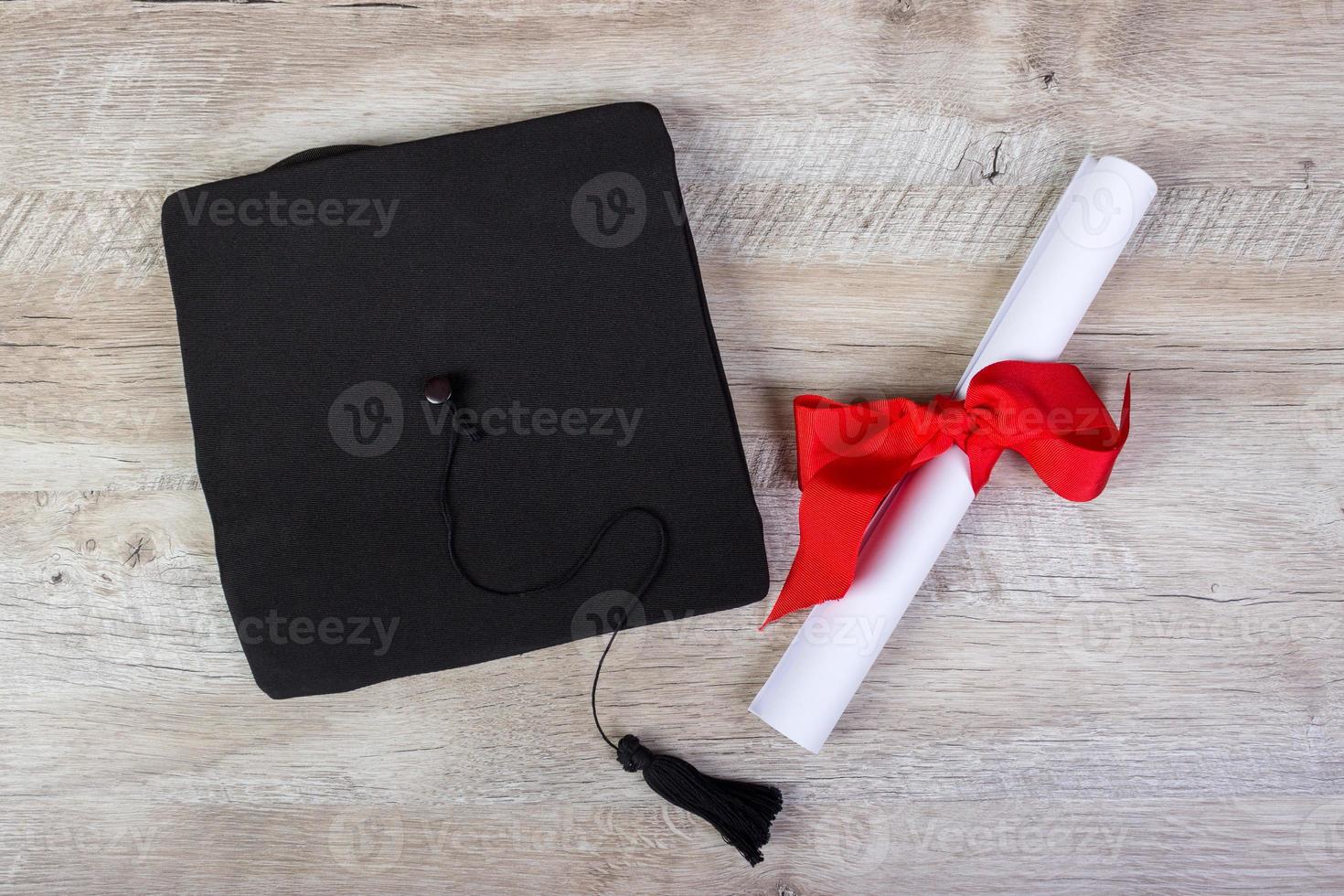 graduation cap, hat with degree paper on wood table graduation concept photo