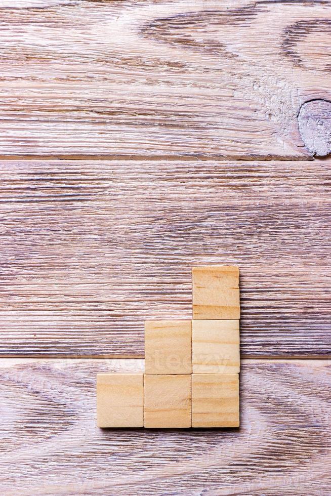 A wooden blocks cube over black wooden textured background with copy space for add word text title. Concept or conceptual Wood block stair or three steps. Cubic photo