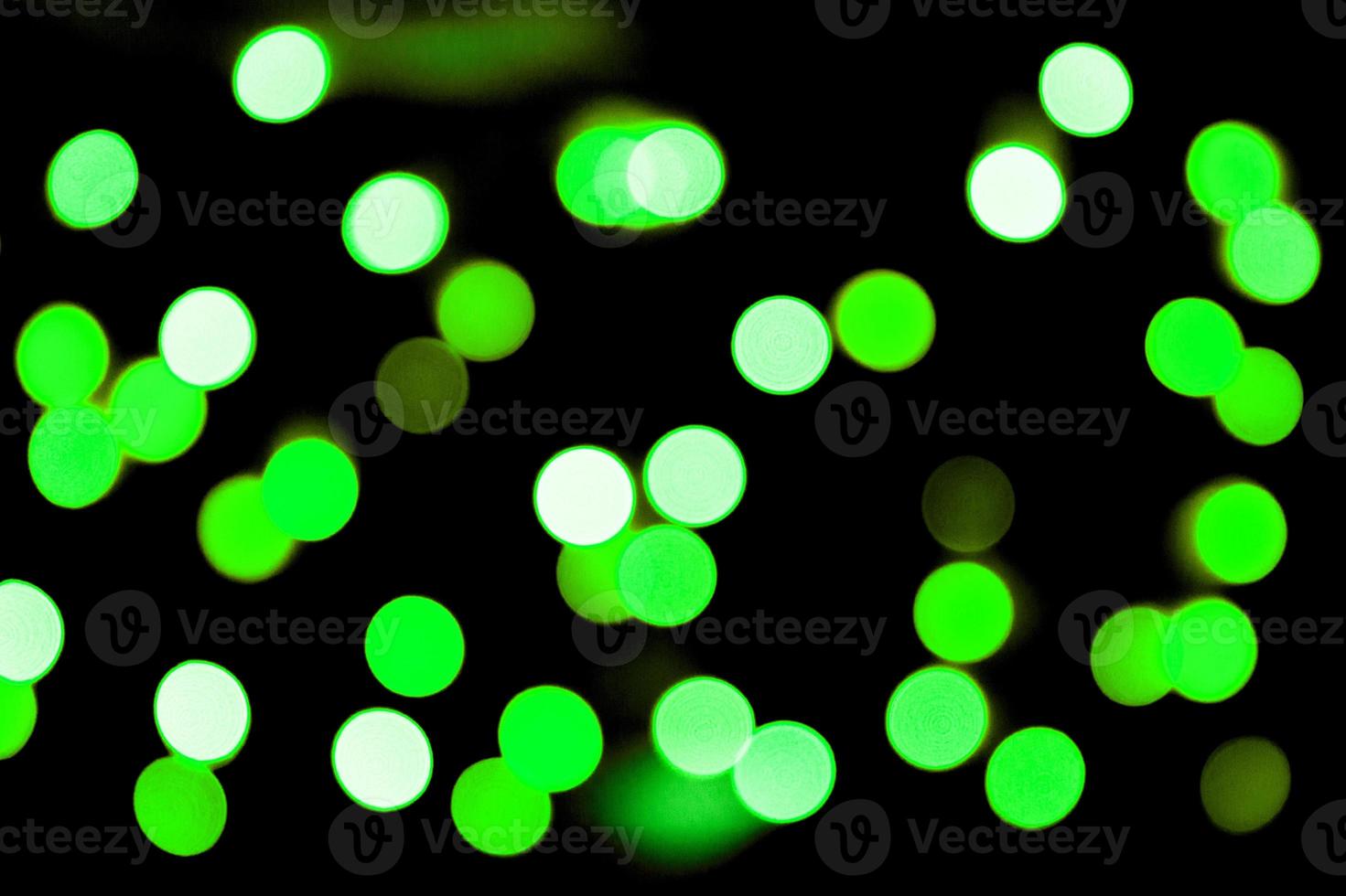Unfocused abstract colourful bokeh black background. defocused and blurred many round green light photo