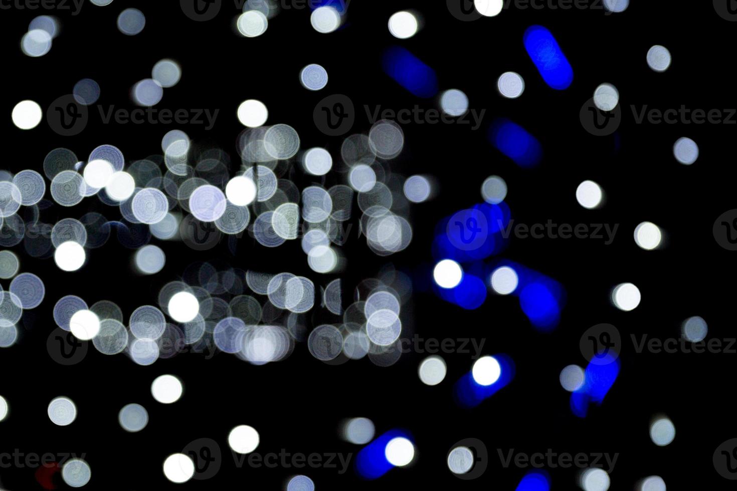 Abstract bokeh of white city lights on black background. defocused and blurred many round light photo