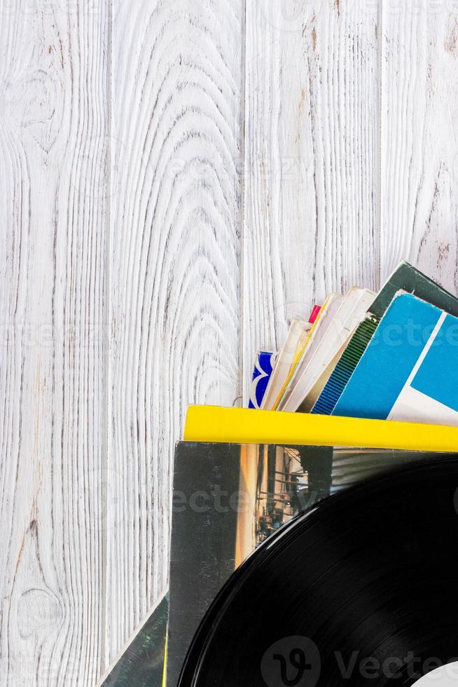 Black vinyl records on the wooden table, selective focus with copy space. Top view photo