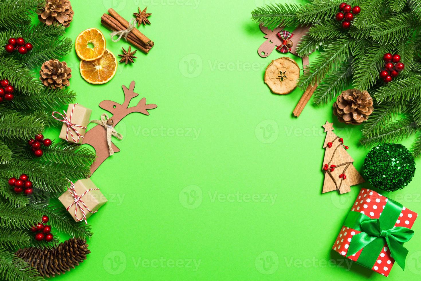 vista superior de adornos navideños sobre fondo verde. concepto de vacaciones de año nuevo con espacio de copia foto