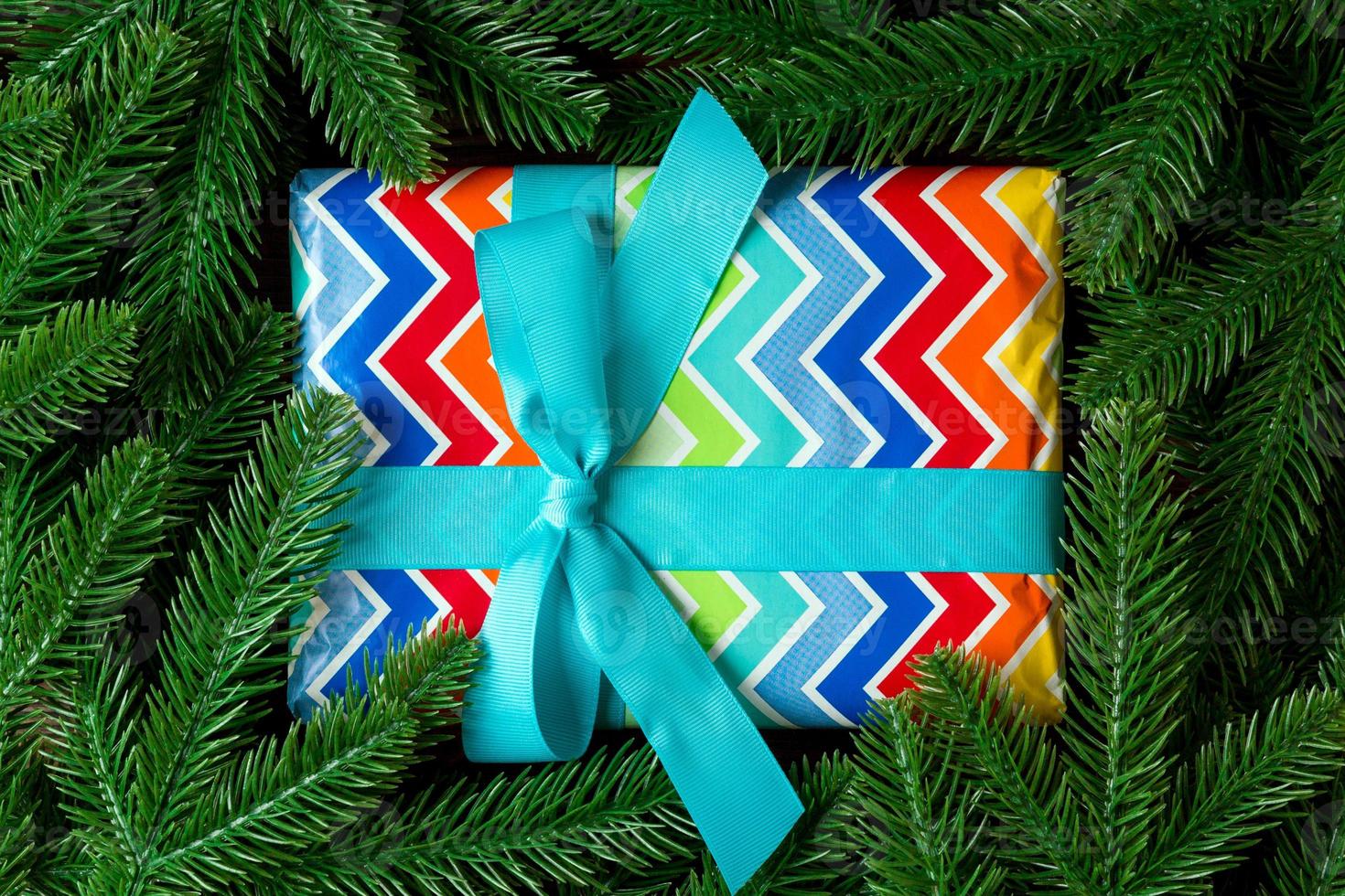 Top view of New Year gift box decorated with fir tree branch. Merry Christmas concept with empty space for your design photo