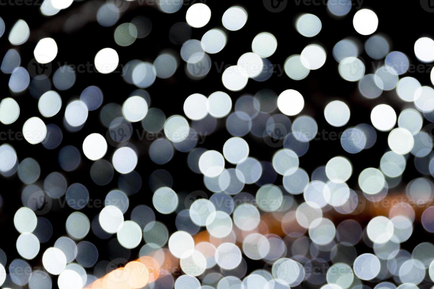 Abstract bokeh of white city lights on black background. defocused and blurred many round light photo