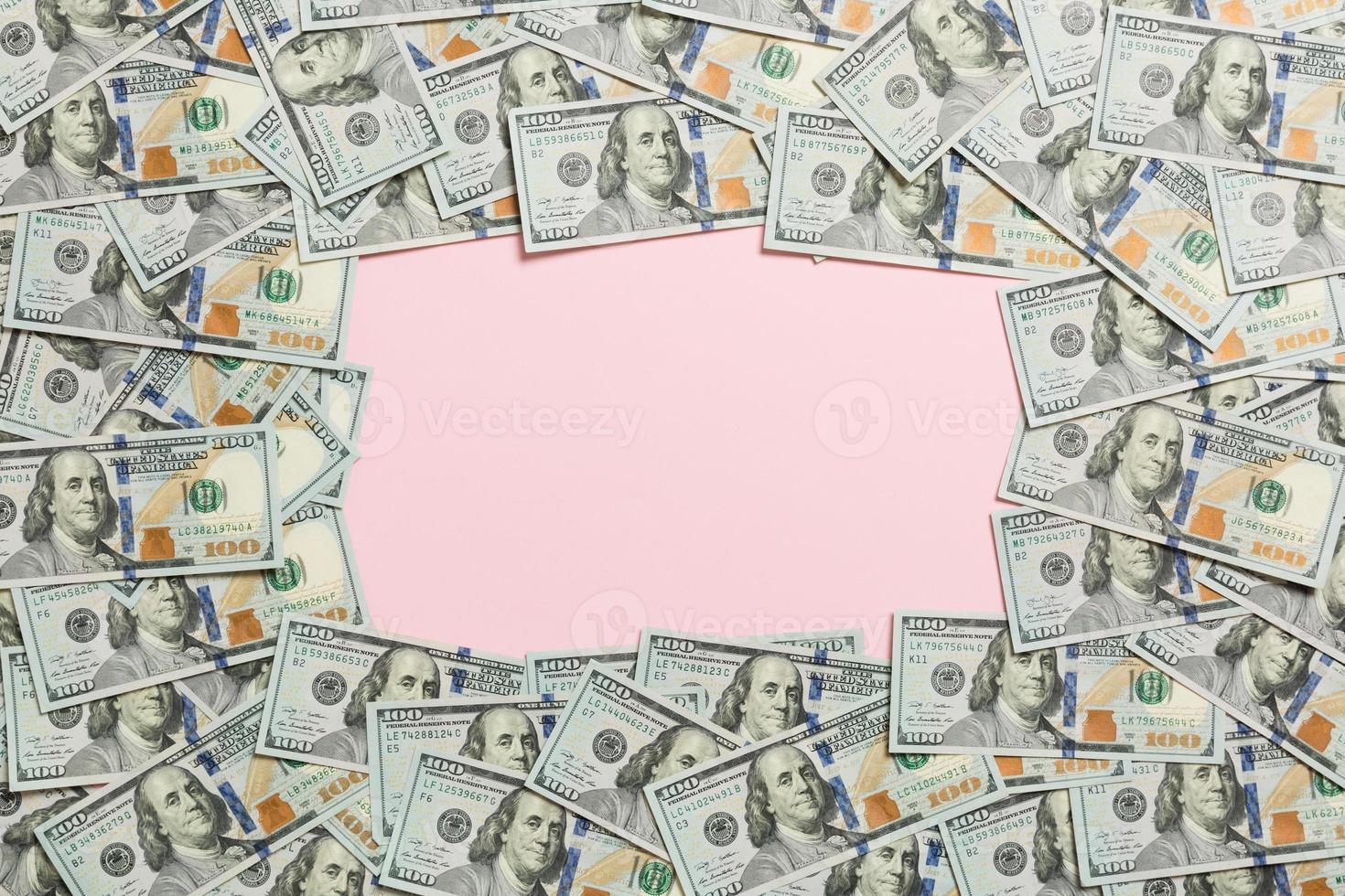 Frame made of dollars with copy space in the middle. Top view of business concept on pink background with copy space photo