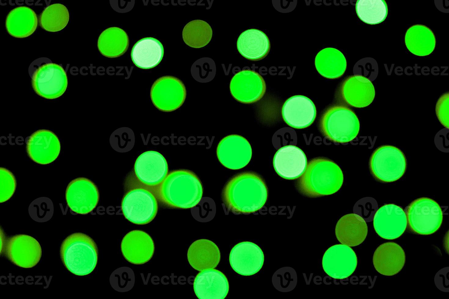 Unfocused abstract colourful bokeh black background. defocused and blurred many round green light photo