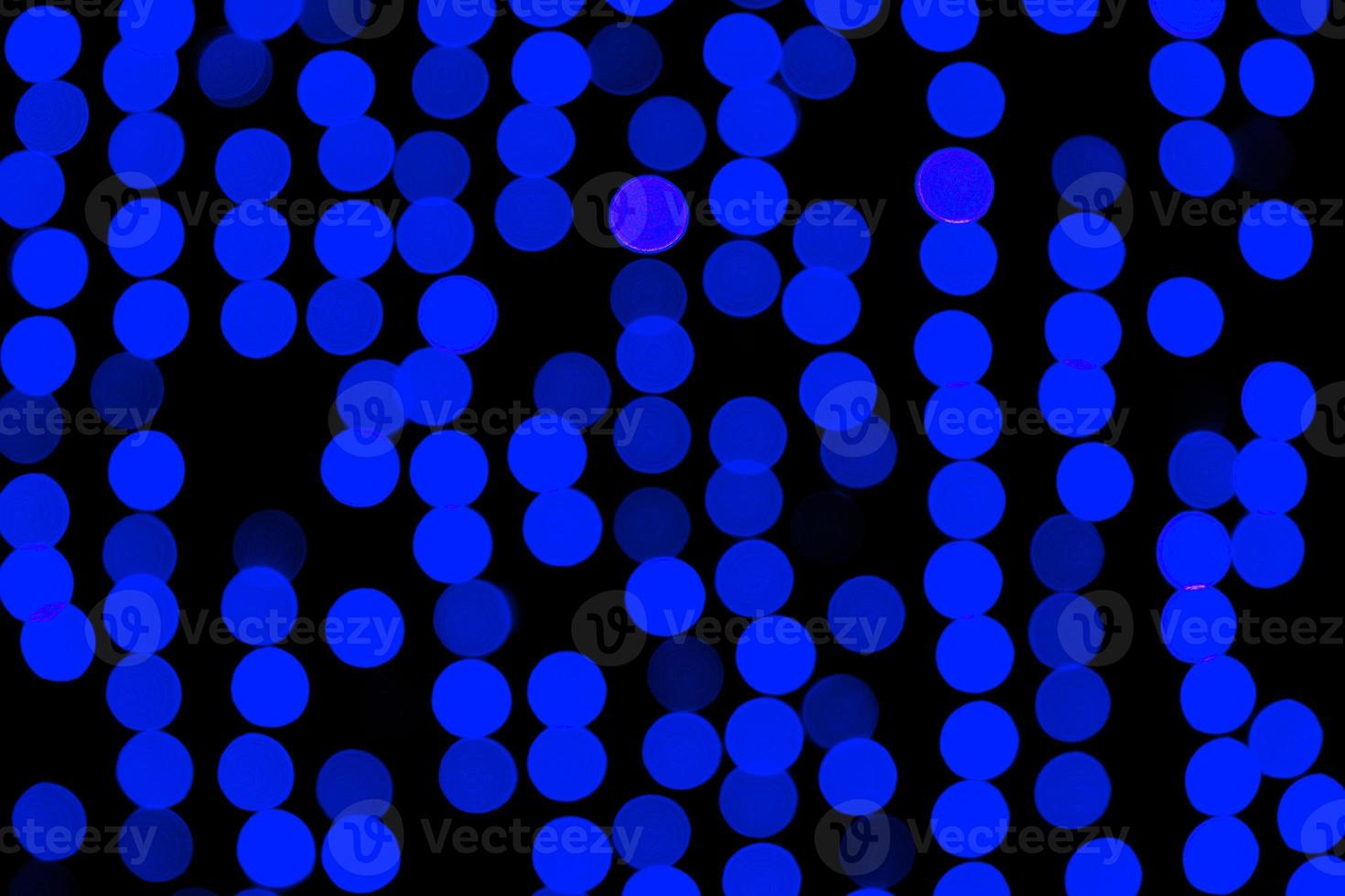 Unfocused abstract dark blue bokeh on black background. defocused and blurred many round light photo