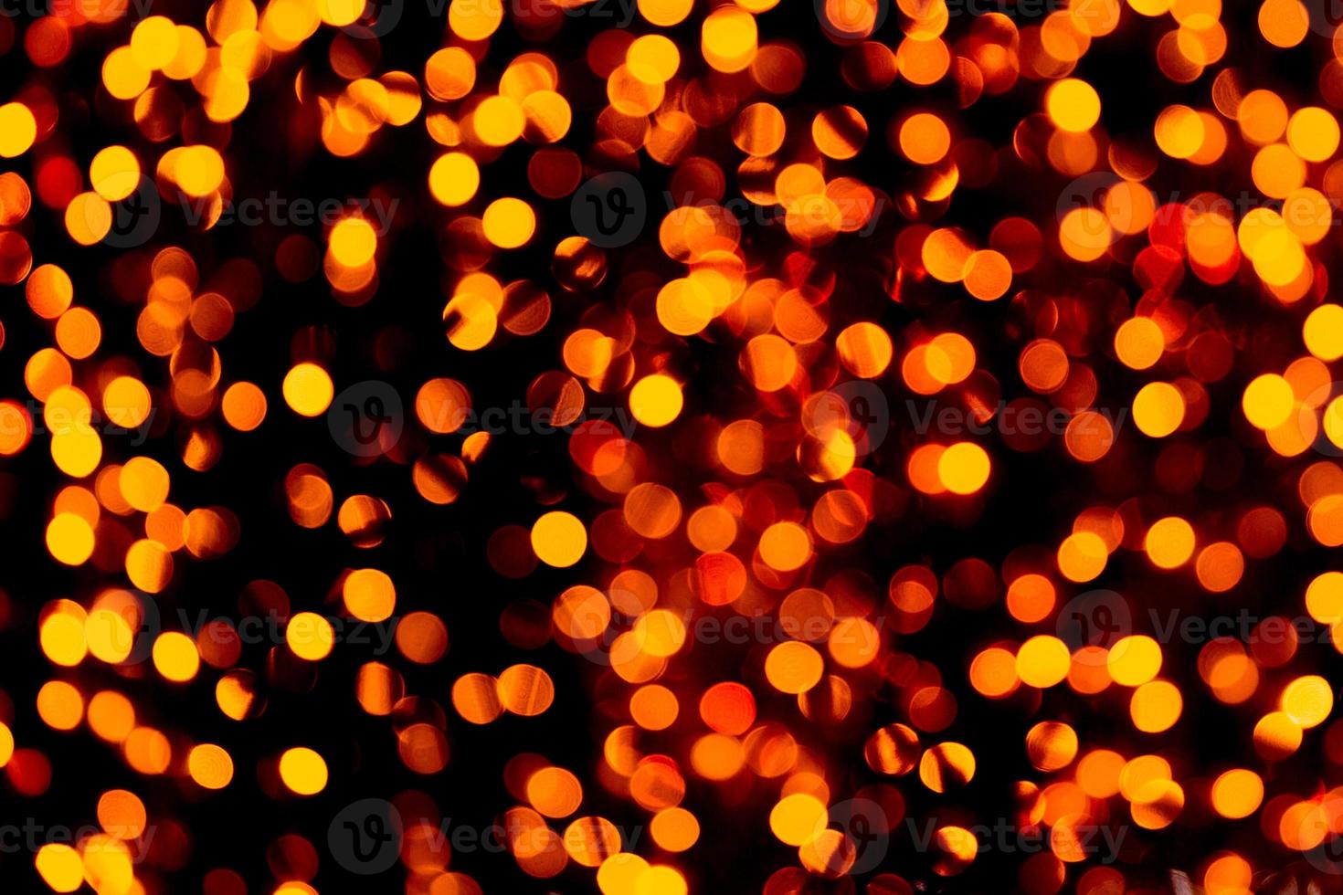 Unfocused abstract gold bokeh on black background. defocused and blurred many round light photo