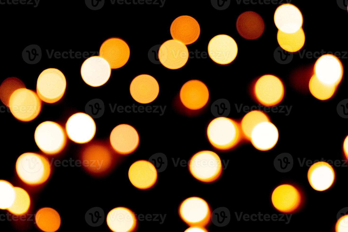Unfocused abstract gold bokeh on black background. defocused and blurred many round light photo