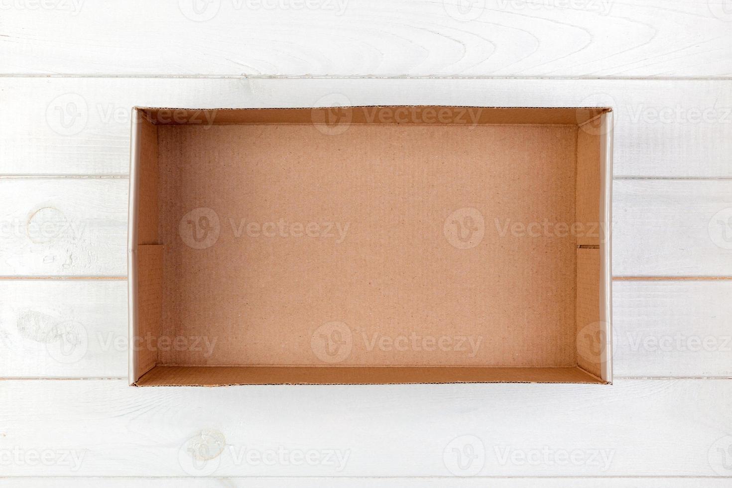 Empty Cardboard box on a white wooden background top view photo