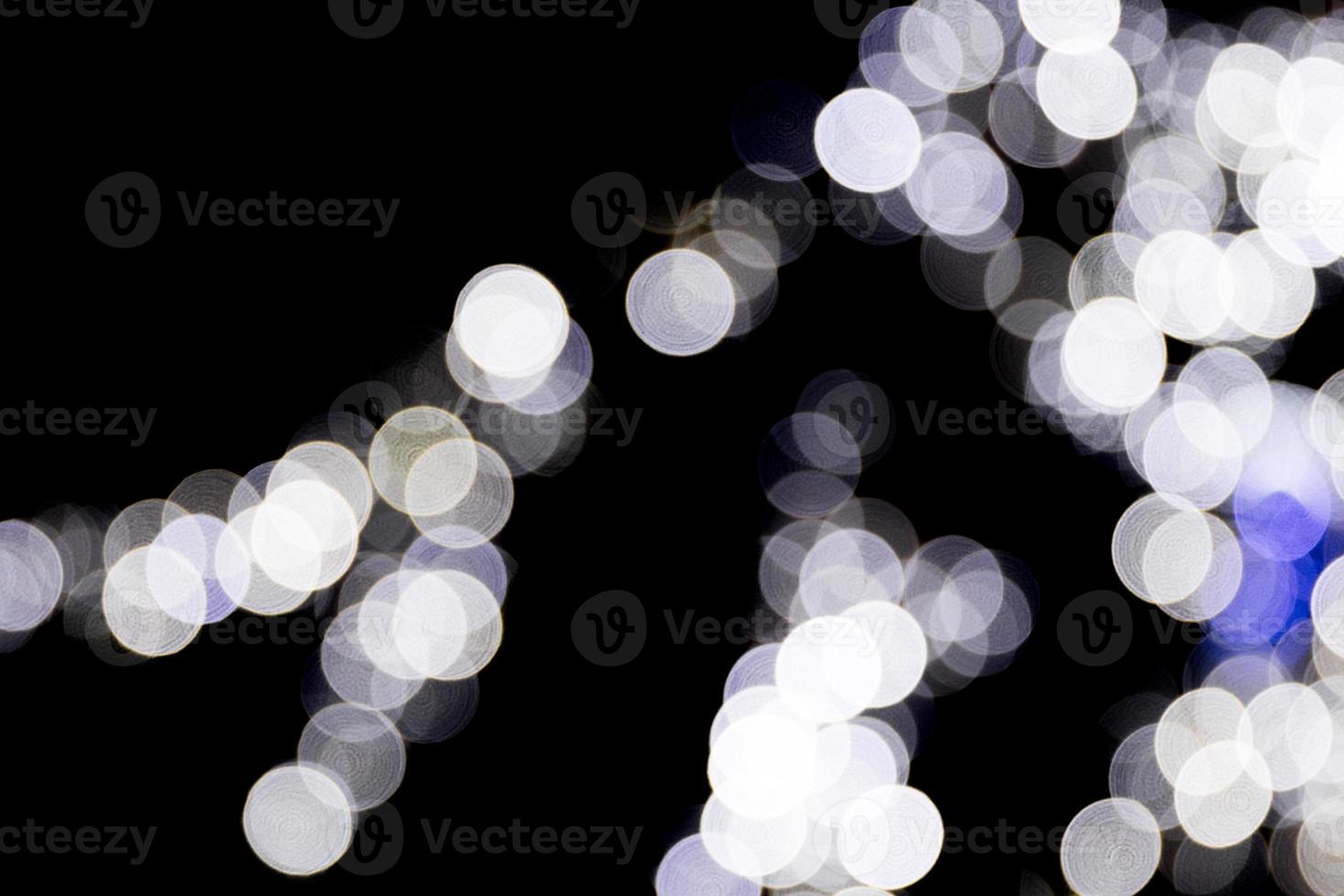 Unfocused abstract colourful bokeh with blue lamp on black background. defocused and blurred many round light photo