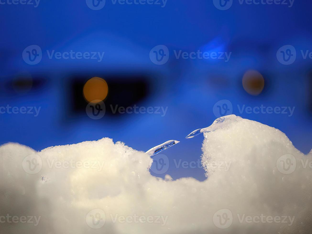 cerrar la nieve en forma de hielo afilado en la distancia, copos de nieve blancos en las ventanas bajo el cielo azul saludos de temporada, feliz navidad, papel tapiz de invierno foto