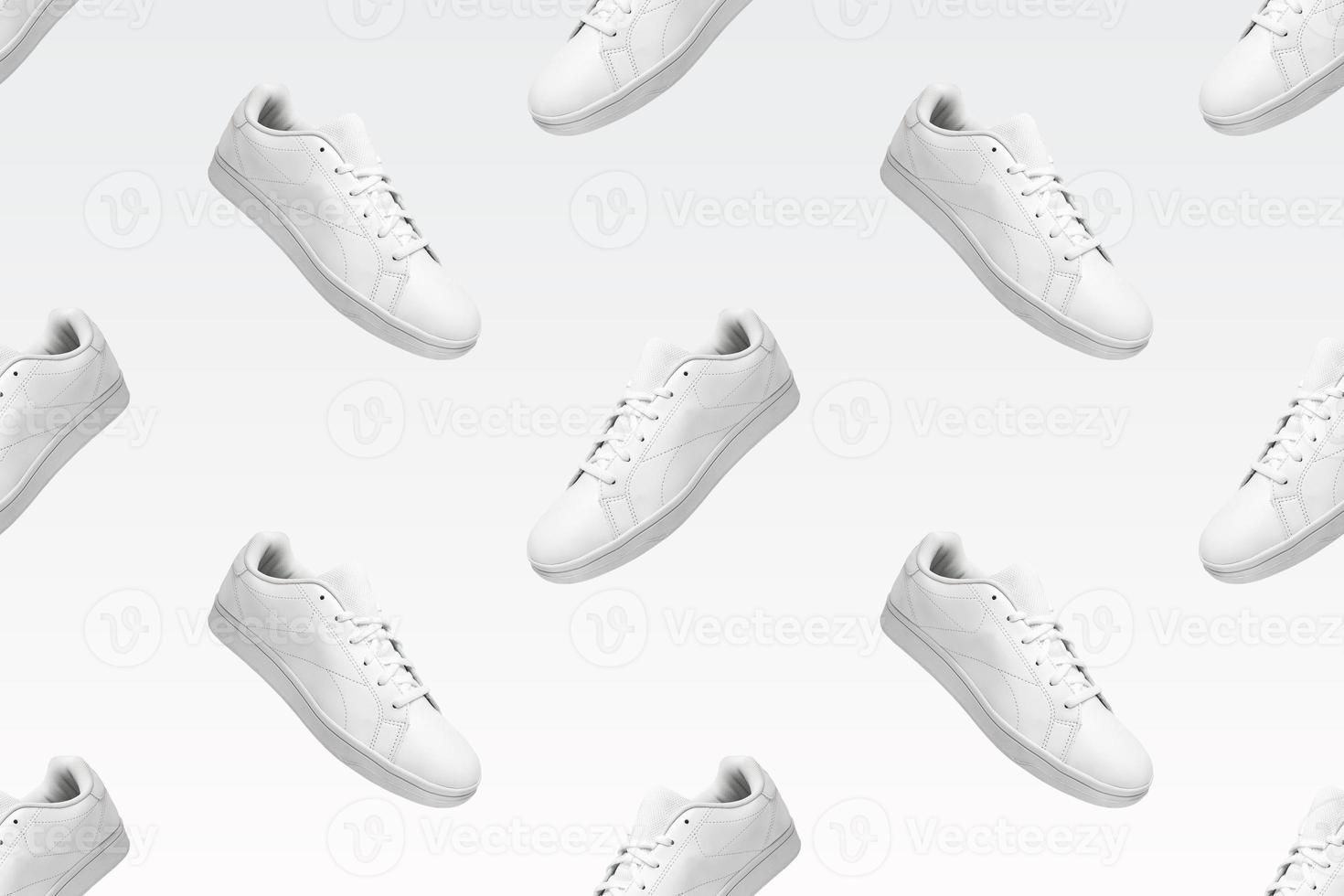 Pattern of white sneakers isolated on white background. Sportive pair of shoes for mockup. Fashionable stylish sports casual shoes. Modern and minimalist wallpaper of fashion lifestyle. photo