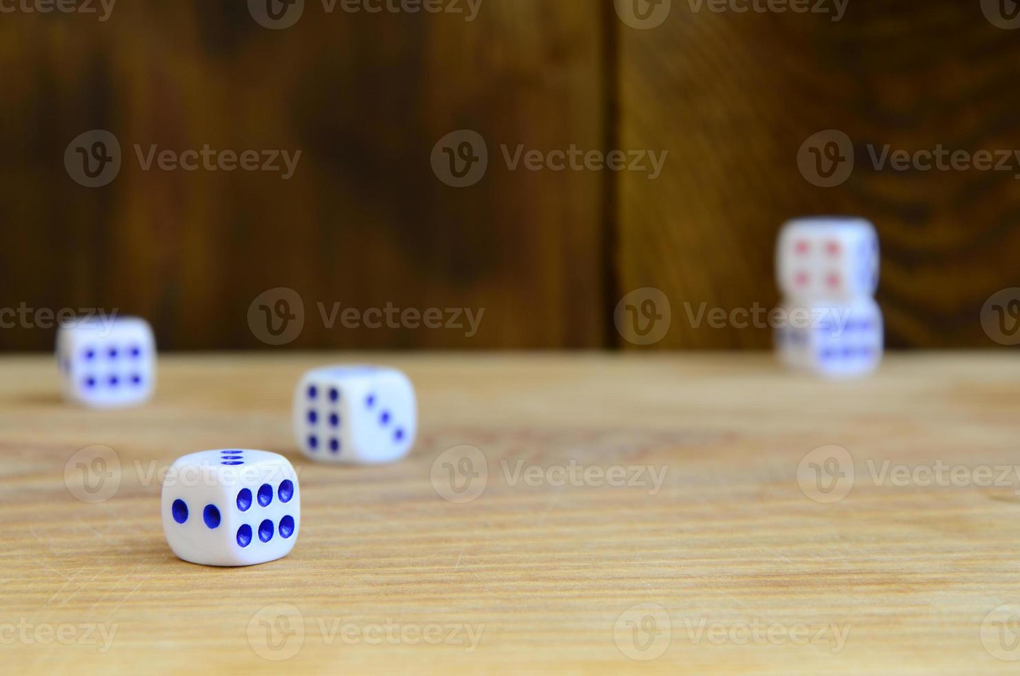 A few dice lies on the surface of natural wood. Items for generating numbers from one to six in the form of points that are painted on the side of cubes. The concept of gambling photo