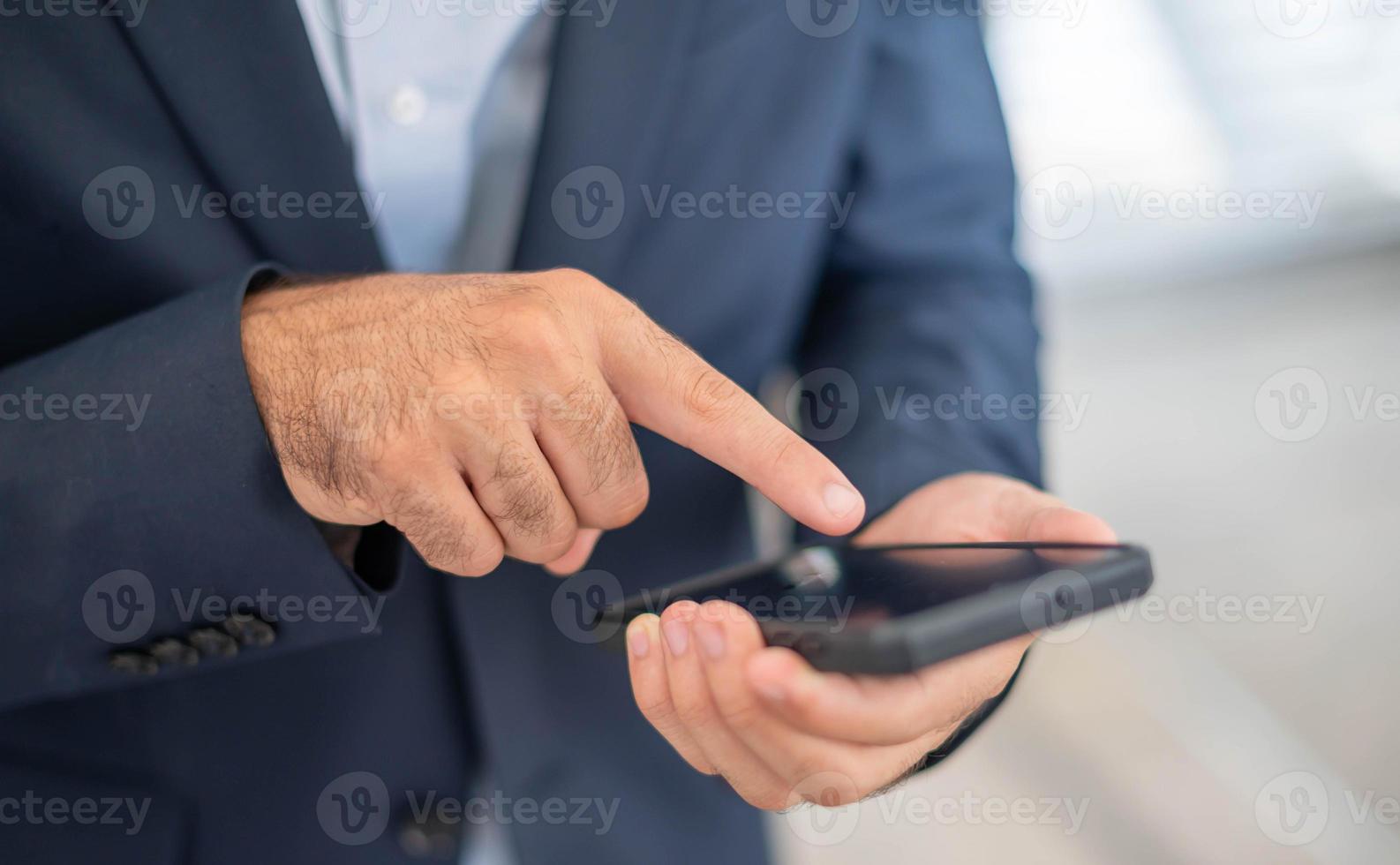 Male hand touching and looking at a smartphone for search and find something to use, or prepare to pay with e-payment system on his phone. photo
