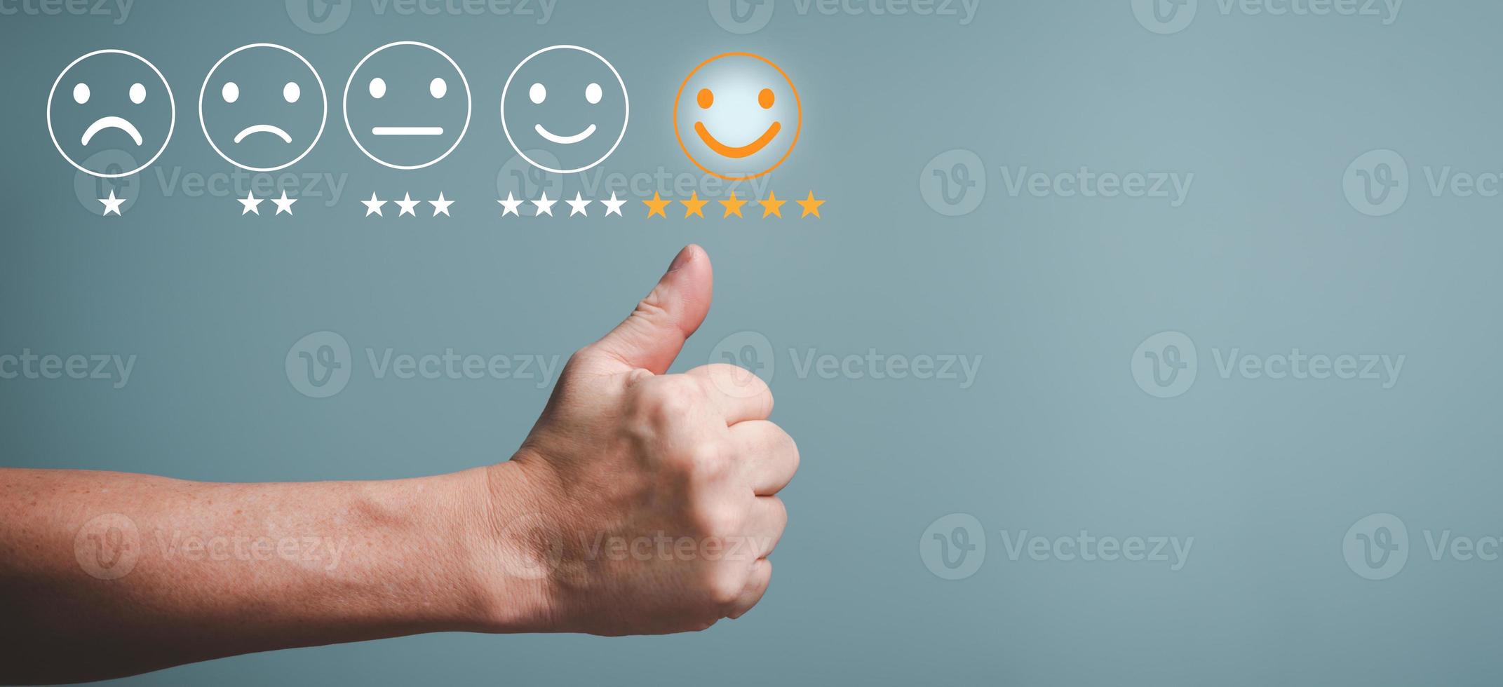 Customer service satisfaction concept, Young businessman touching happy face screen, raised thumbs up, smile satisfaction rating icon face. photo