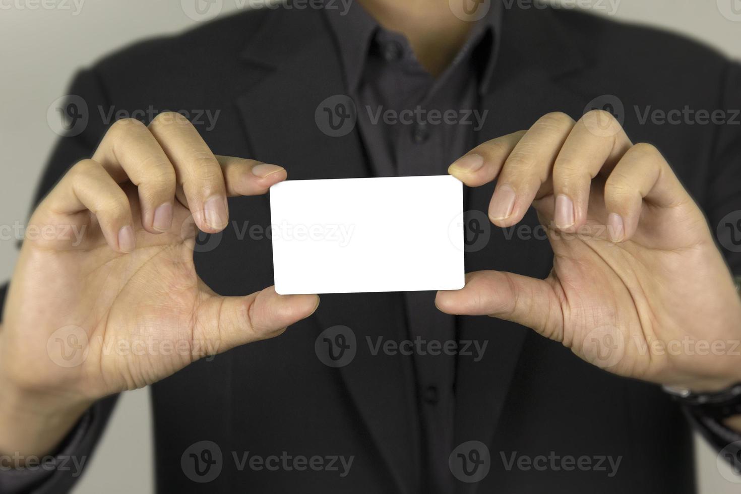 la mano de un hombre que sostiene una tarjeta blanca para el diseño de concepto entre tarjetas, y un hombre de dardo inteligente que muestra una tarjeta de identificación falsa blanca sobre fondo blanco. foto