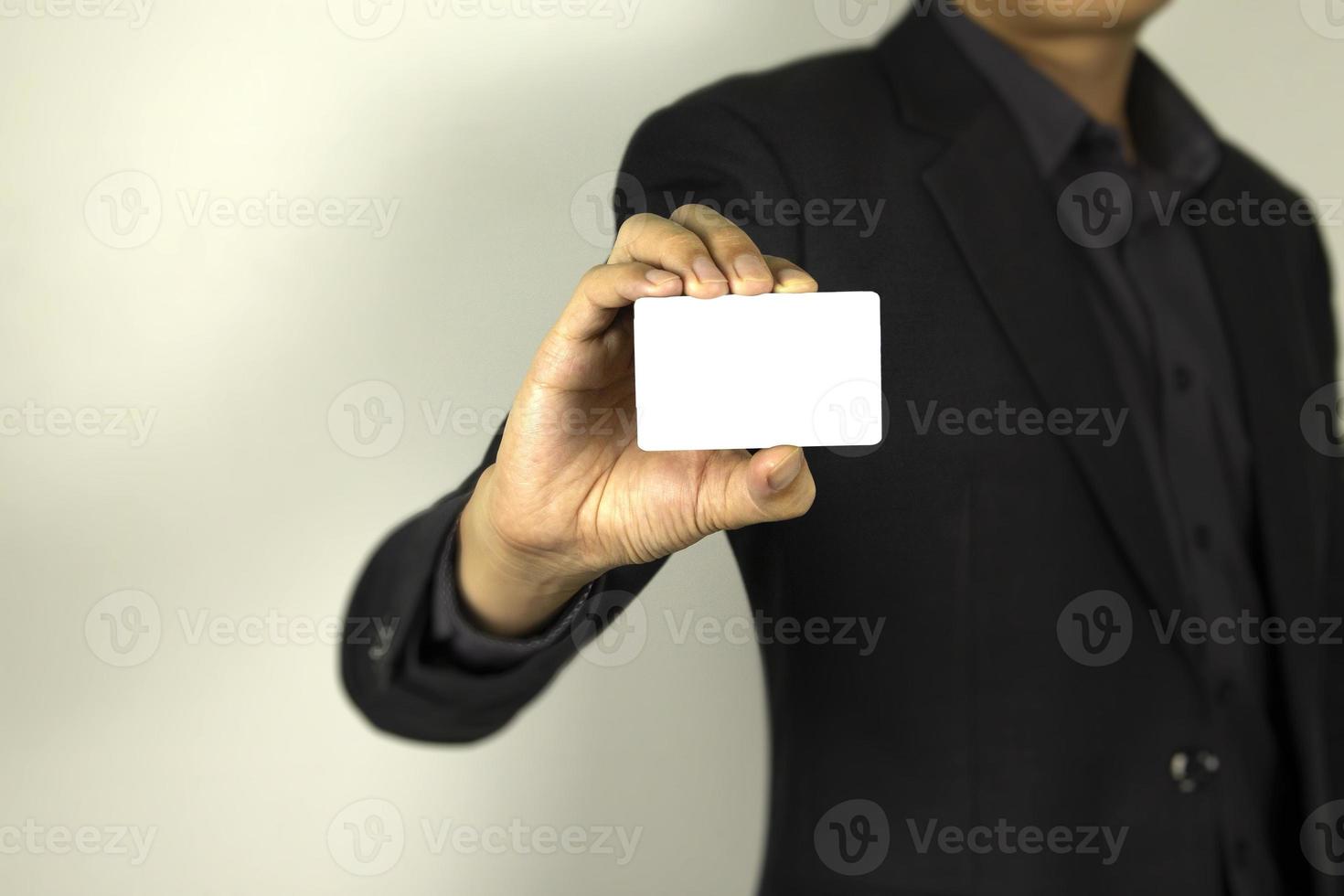 hombre de negocios con traje inteligente y con una tarjeta de identificación en la mano, un hombre inteligente con una tarjeta blanca falsa, utilizada en el afiche de diseño de tarjetas. foto