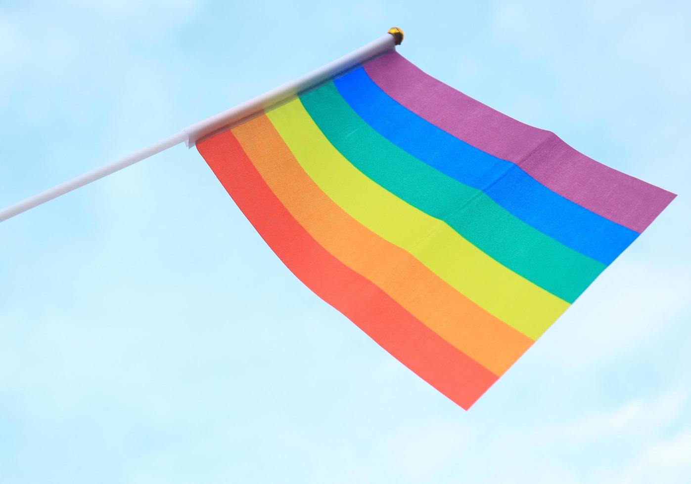 bandera del arco iris lgbt fondo azul. concepto de libertad y diversidad de género foto