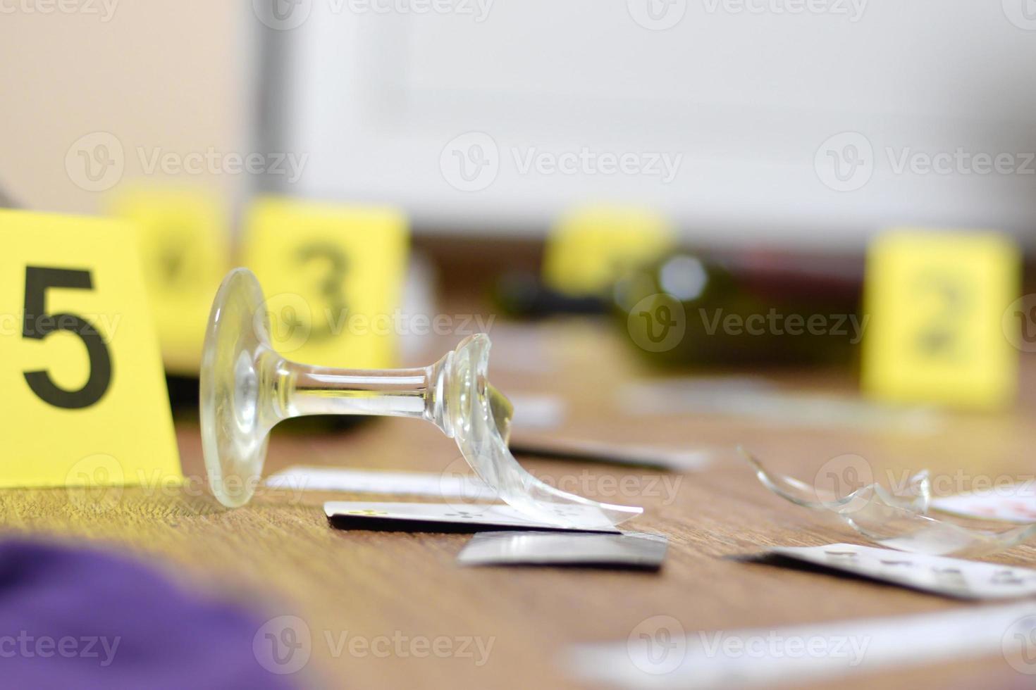 vidrio roto y botella de vino marcados como evidencia durante la investigación de la escena del crimen. muchos marcadores amarillos con números foto