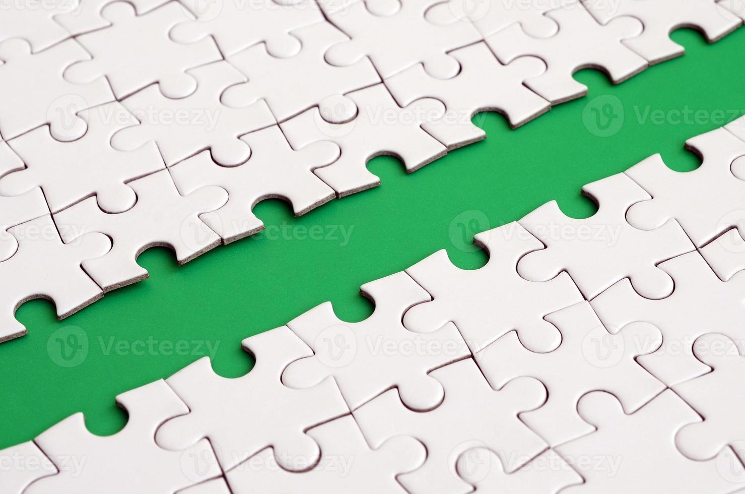 The green path is laid on the platform of a white folded jigsaw puzzle. Texture image with copy space for text photo