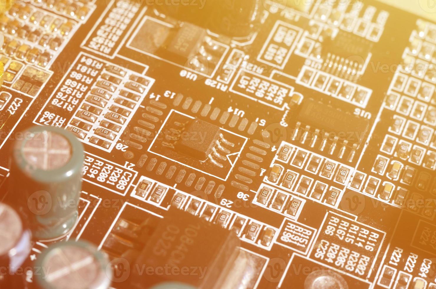 A toned macro image of a computer board with many small technological elements. Extremely shallow depth of field. Abstract technological background photo