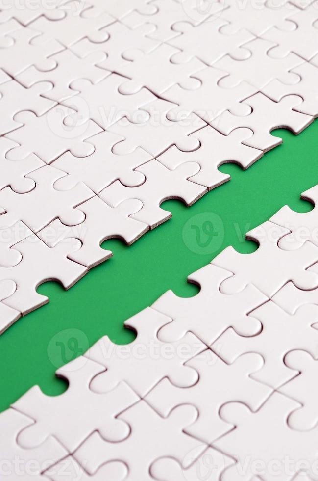 The green path is laid on the platform of a white folded jigsaw puzzle. Texture image with copy space for text photo