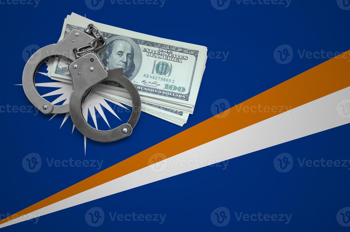 Marshall Islands flag with handcuffs and a bundle of dollars. The concept of breaking the law and thieves crimes photo