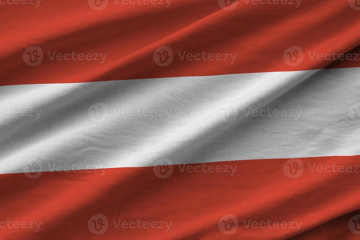 Austria flag with big folds waving close up under the studio light indoors. The official symbols and colors in banner photo