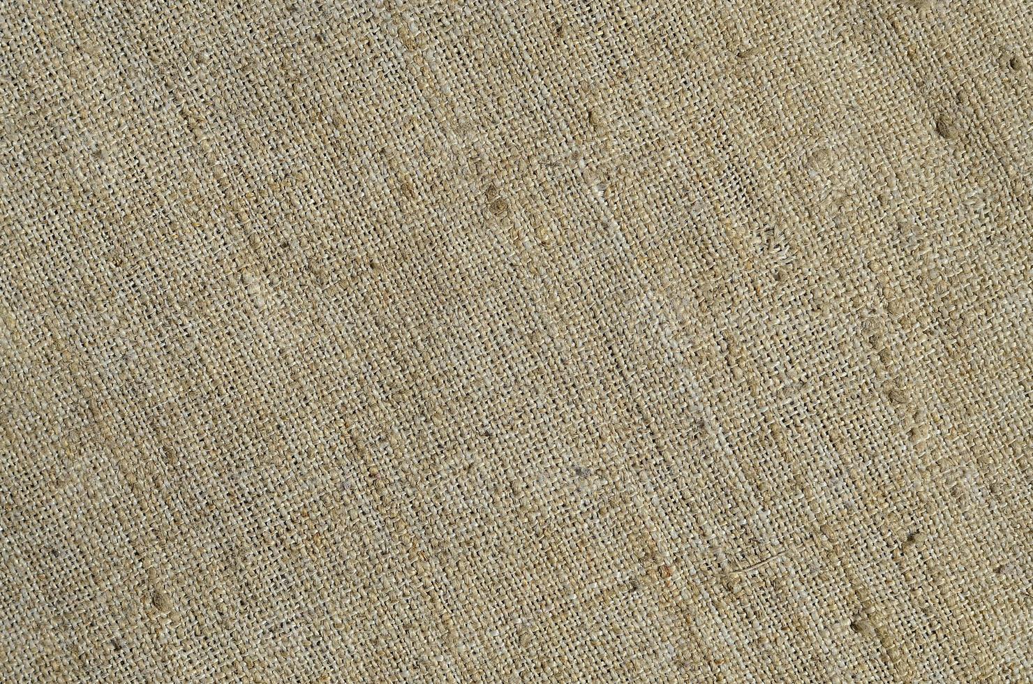 Texture of a gray canvas made of old and coarse burlap. Top view photo