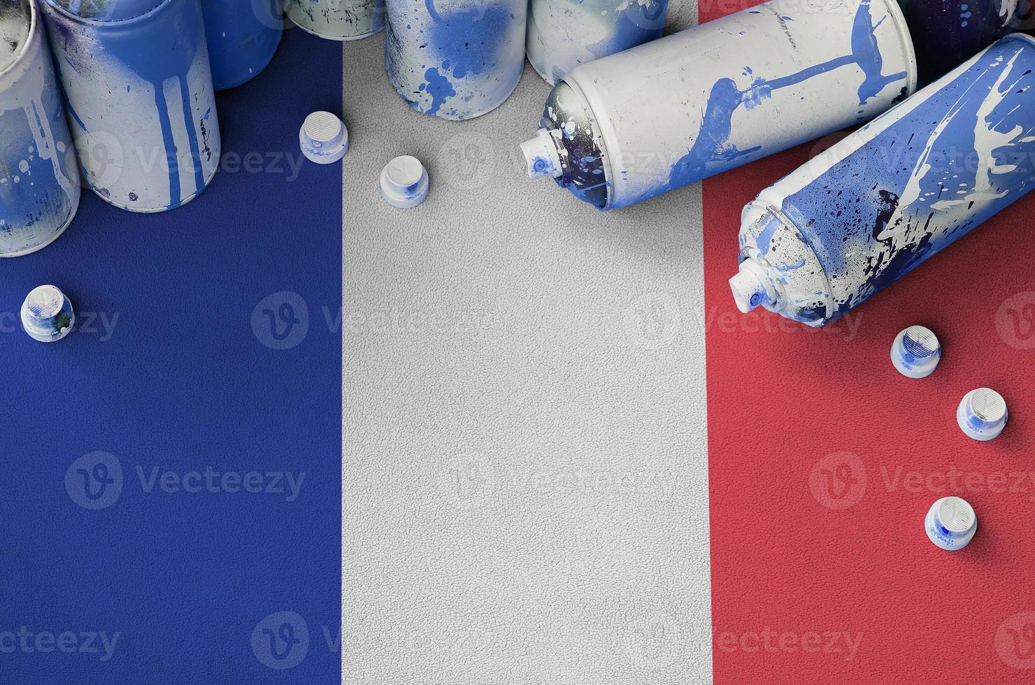 bandera de francia y pocas latas de aerosol usadas para pintar graffiti. concepto de cultura de arte callejero foto