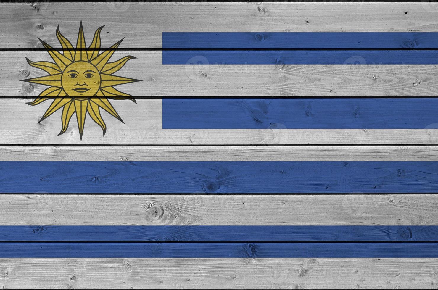 Uruguay flag depicted in bright paint colors on old wooden wall. Textured banner on rough background photo