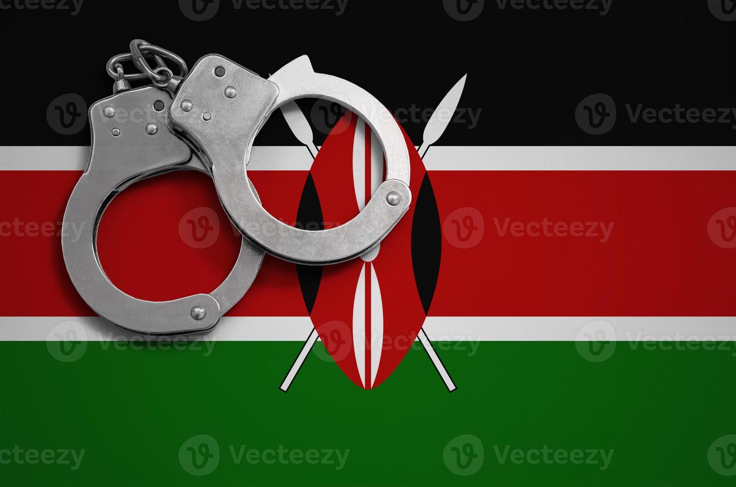 Kenya flag and police handcuffs. The concept of crime and offenses in the country photo