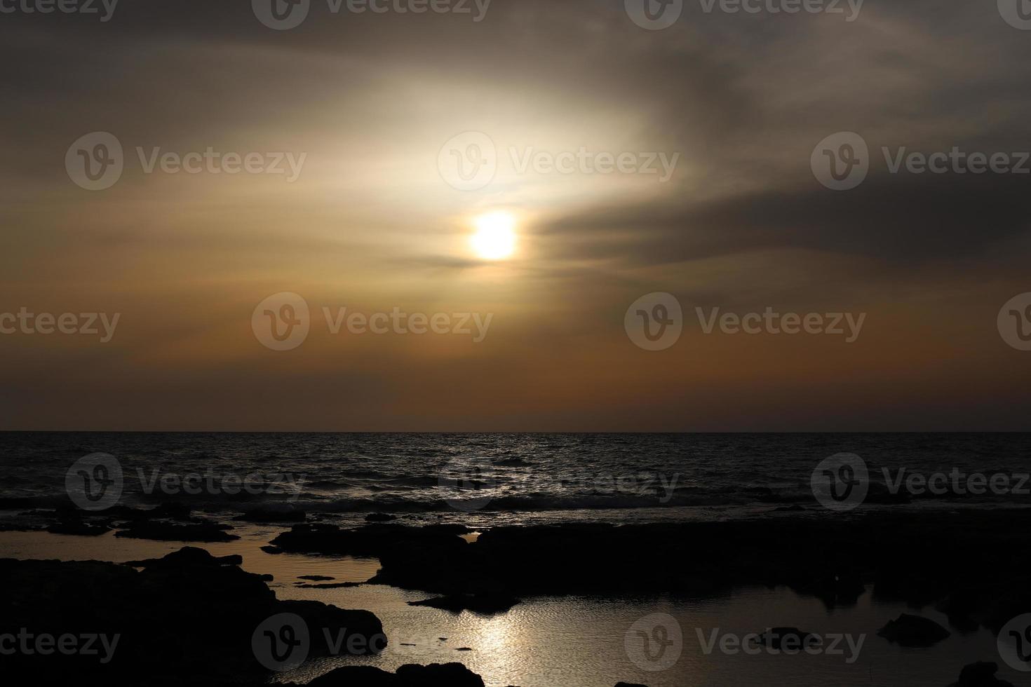 The sun sets below the horizon on the Mediterranean Sea in northern Israel. photo