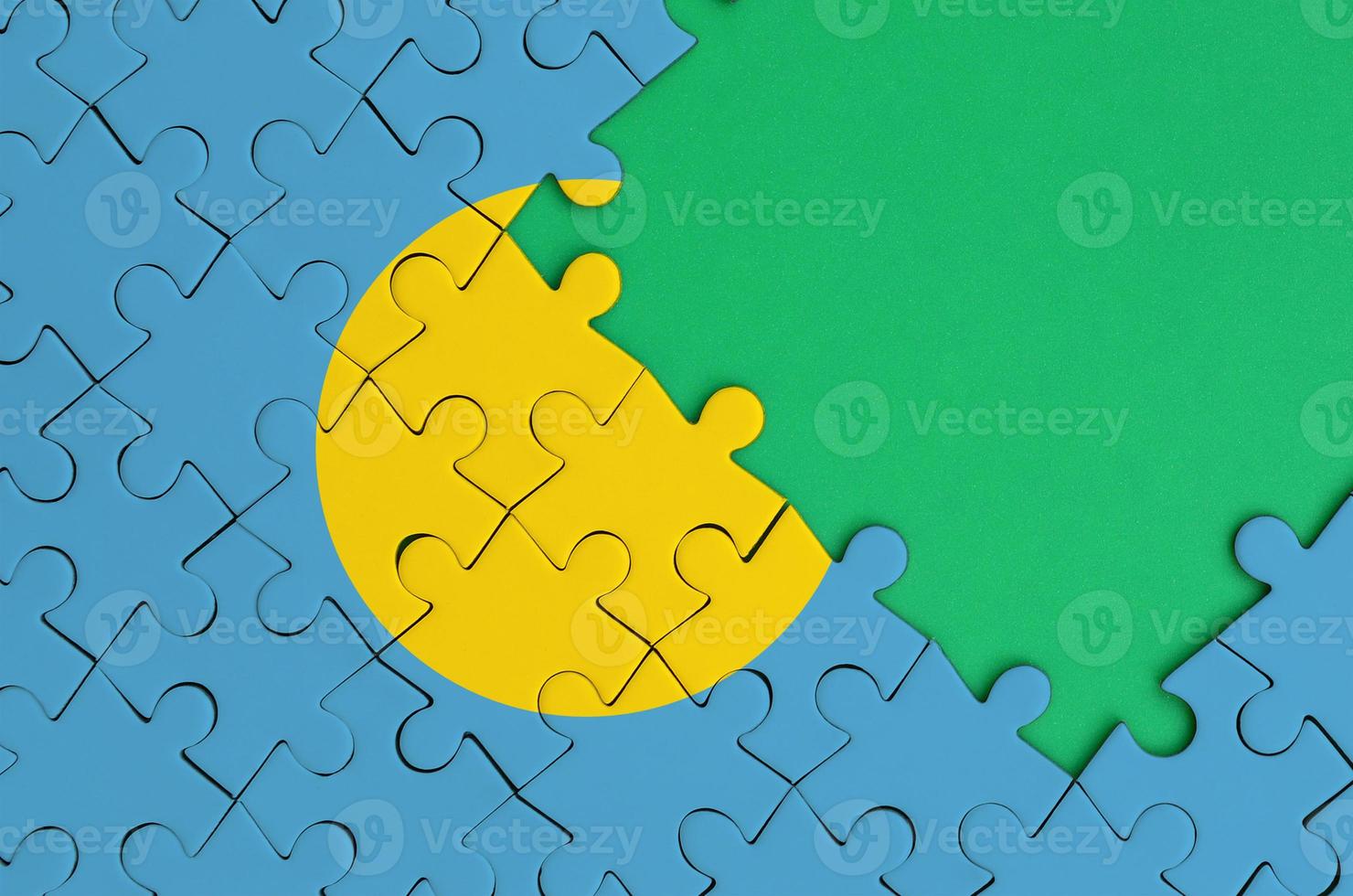 Palau flag is depicted on a completed jigsaw puzzle with free green copy space on the right side photo