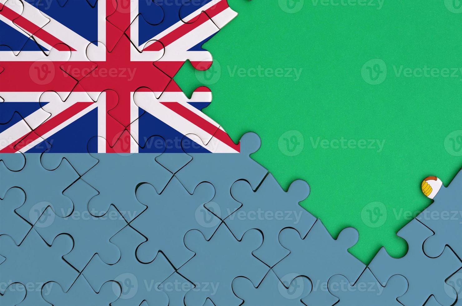 Fiji flag is depicted on a completed jigsaw puzzle with free green copy space on the right side photo