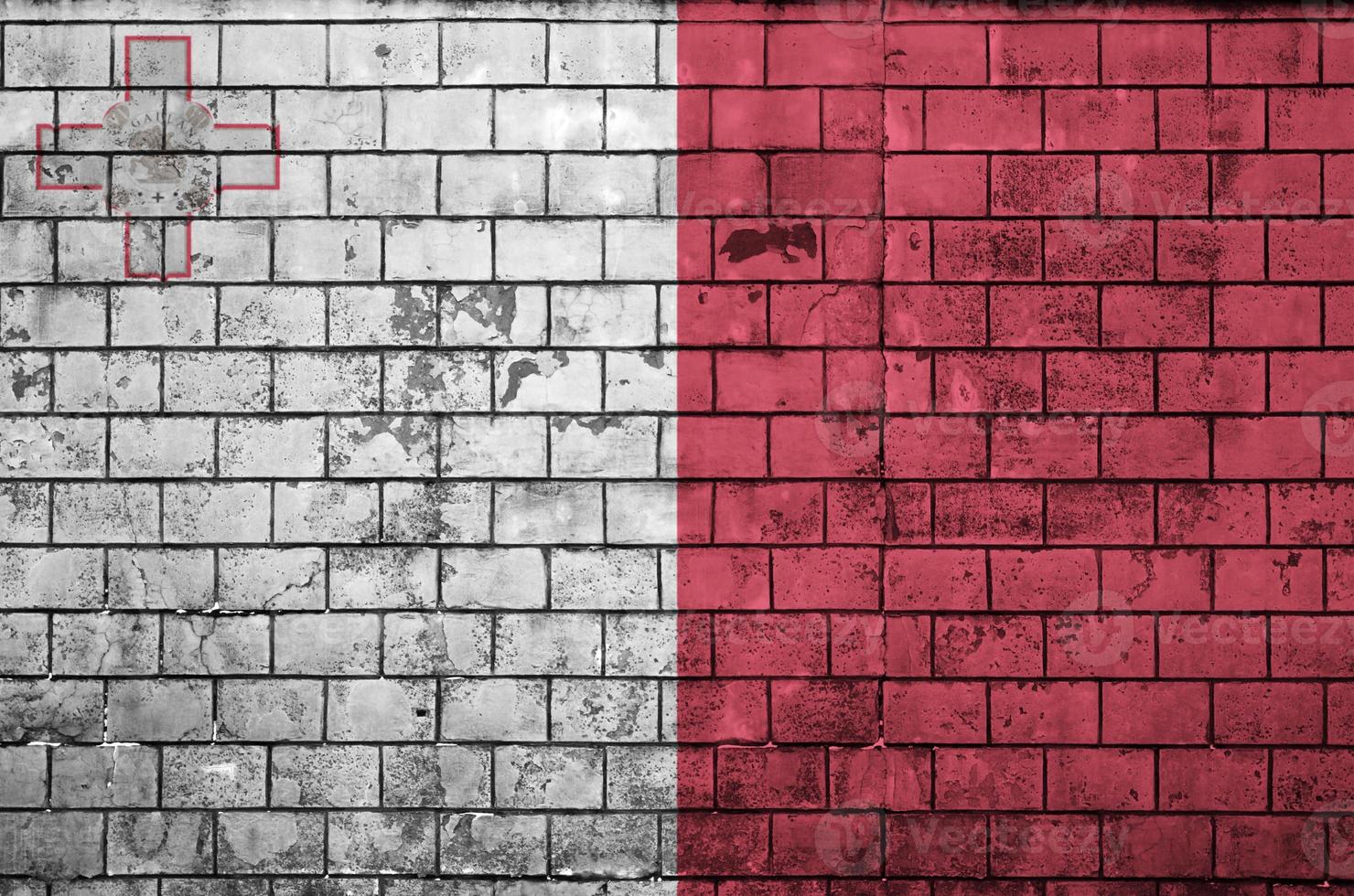 Malta flag is painted onto an old brick wall photo