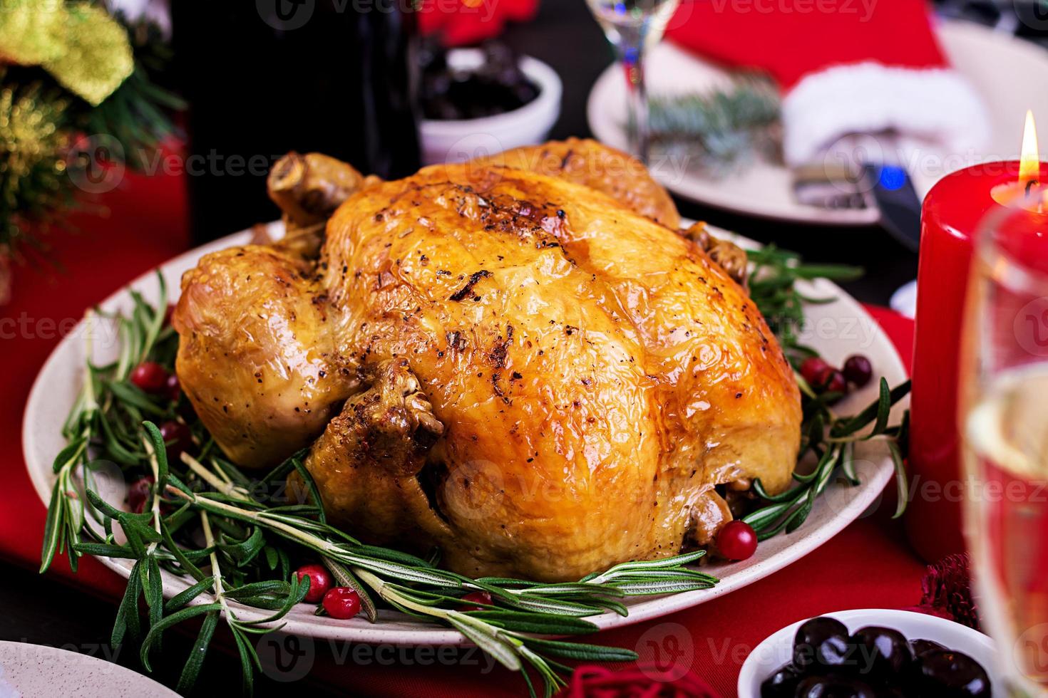 Baked turkey. Christmas dinner. The Christmas table is served with a turkey, decorated with bright tinsel and candles. Fried chicken, table.  Family dinner. photo