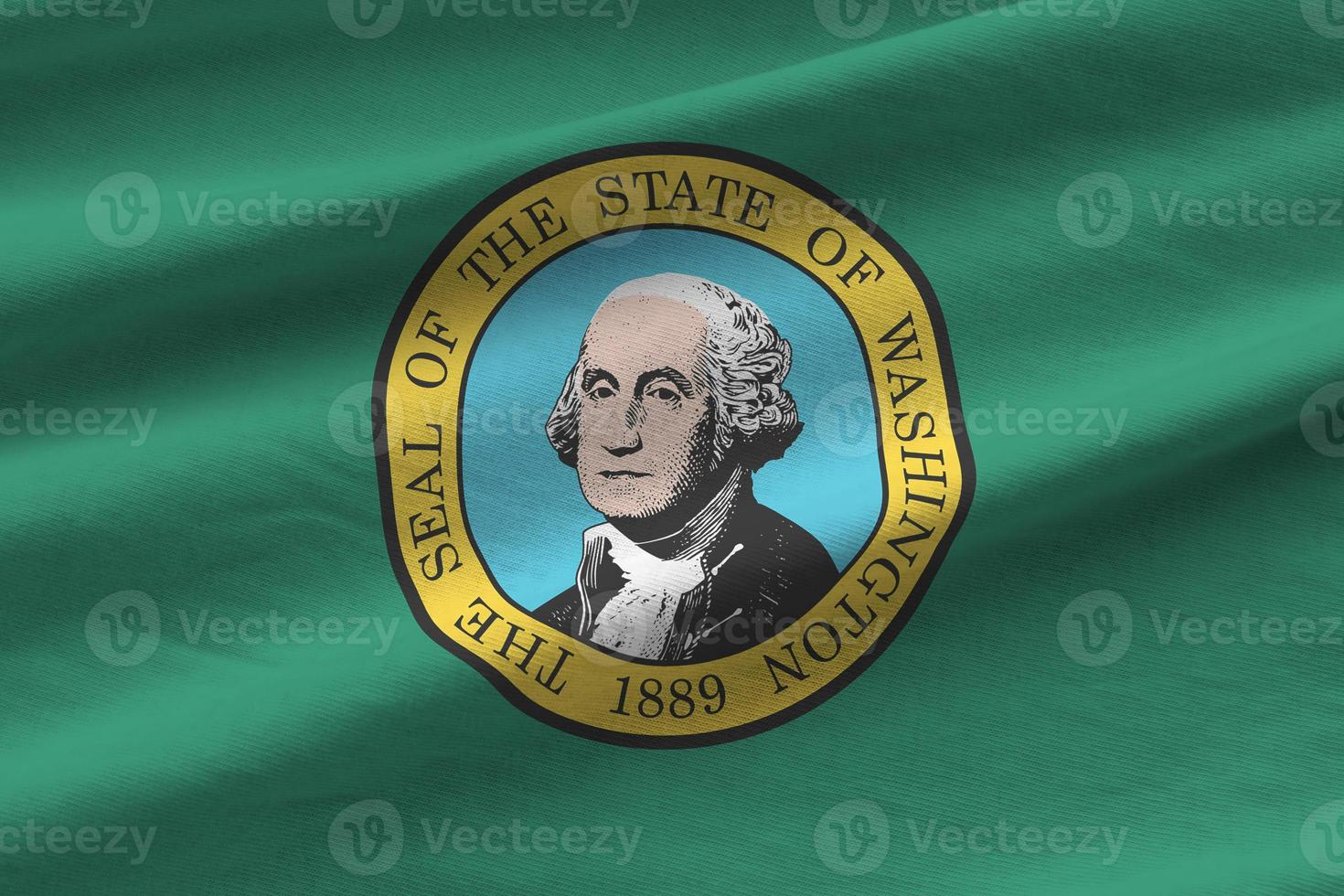 Washington US state flag with big folds waving close up under the studio light indoors. The official symbols and colors in banner photo