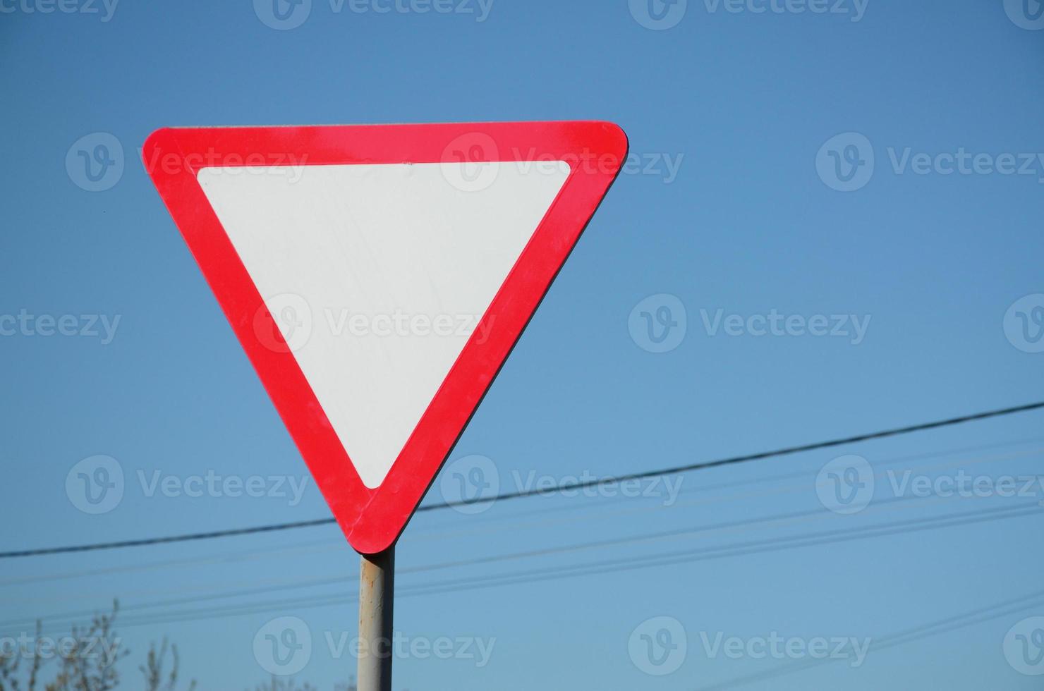 Traffic sign in the form of a white triangle. Give way photo