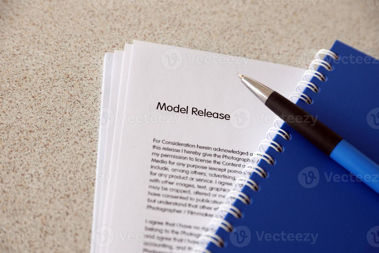 Model release blank form with blue notepad and blue pen lies on photographers table. Model release signing photo