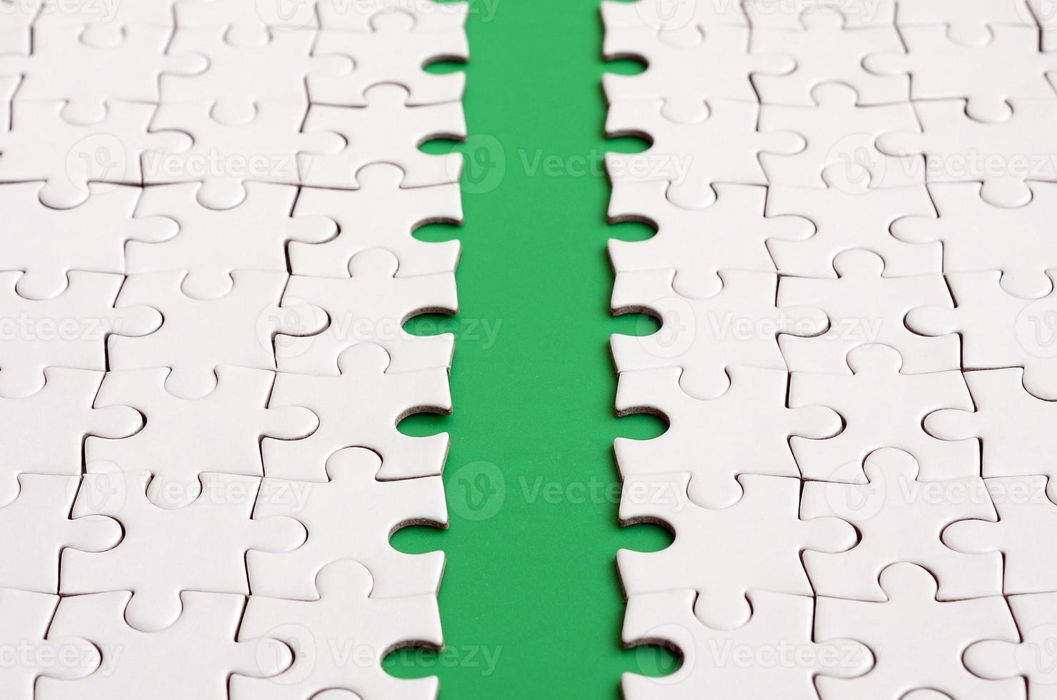 The green path is laid on the platform of a white folded jigsaw puzzle. Texture image with copy space for text photo