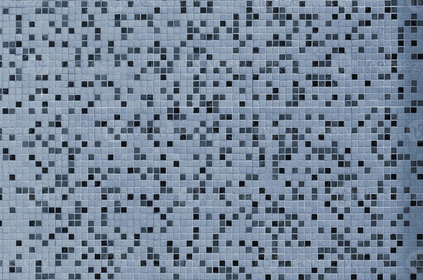 The texture of the wall, decorated with a mosaic of various small square tiles. Abstract pattern of ceramic tiles on the wall photo