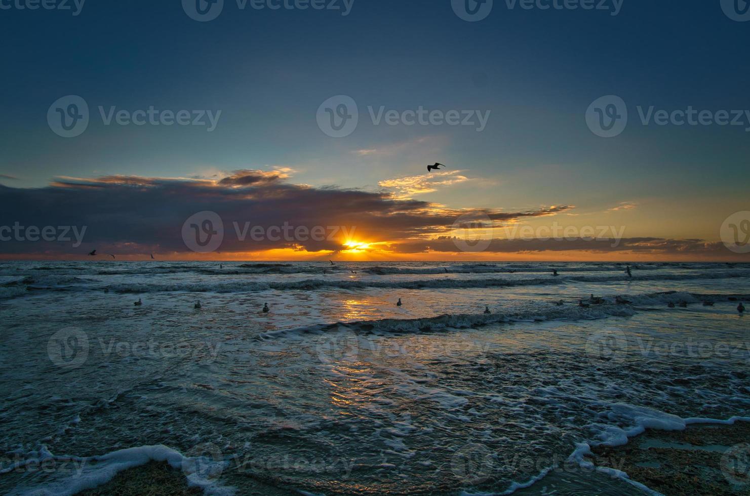Sunset on the beach in Denmark. Waves rolling over the sand. Walk on the coast photo