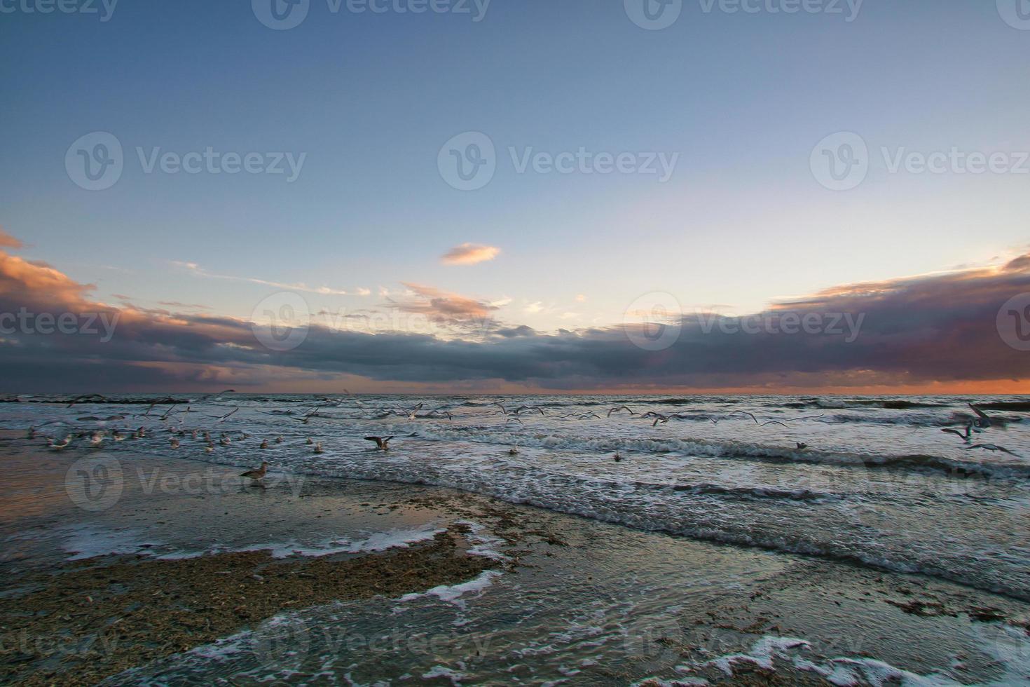 Sunset on the beach in Denmark. Waves rolling over the sand. Walk on the coast photo