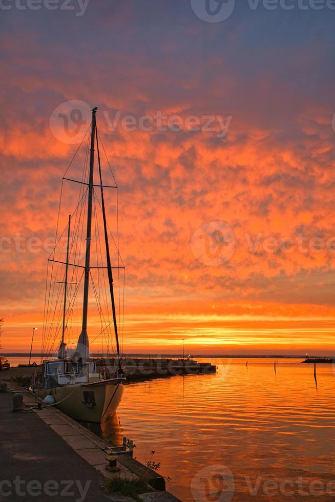 Sailing ship in the harbor of lake Vaettern at sunset. Lighthouse in the background photo