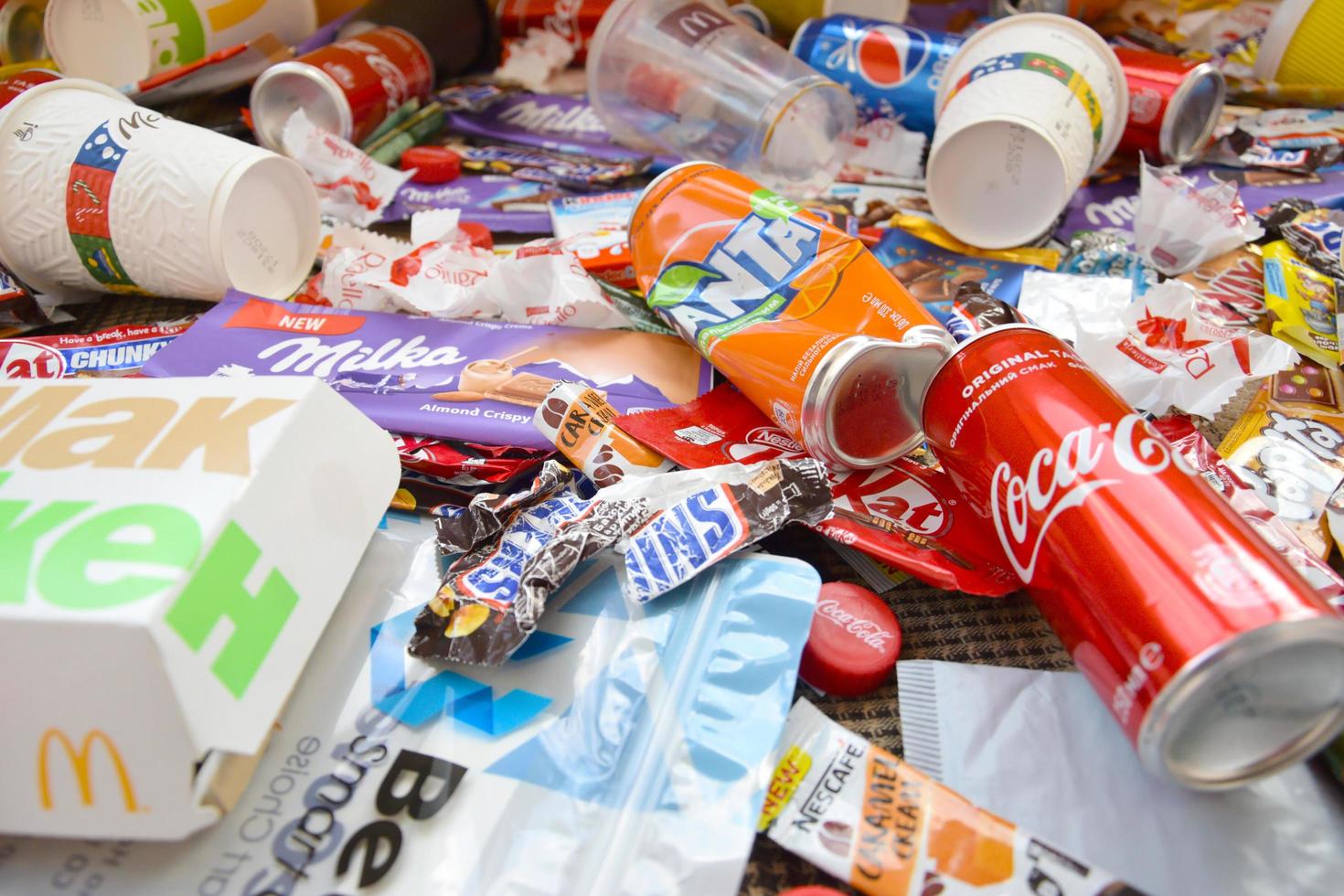 KHARKOV, UKRAINE - MAY 3, 2021 Many wrappings and cans from used products by famous worldwide brands. Pattern of trash of various colors and materials photo