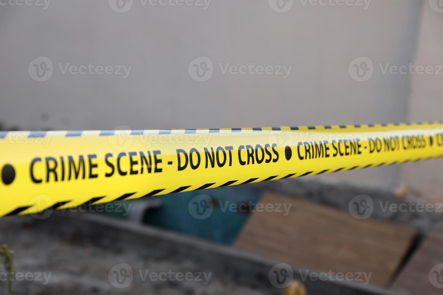 Crime scene tape for covering the area cordon. Yellow tape with blurred forensic law enforcement background in cinematic tone photo